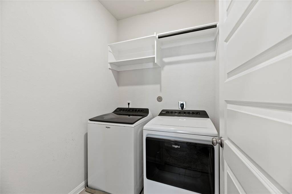 Spacious laundry room with washer and dryer provided.