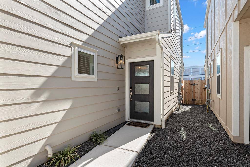 The private front door is tucked to the side of the home and features a front door keypad for keyless entry, as well as a camera doorbell.