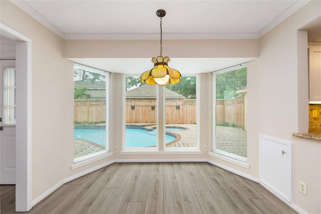 The breakfast nook offers a serene escape with peaceful views of the pool, creating the perfect spot to enjoy your morning coffee or unwind. The tranquil setting, framed by large windows, invites relaxation and peaceful moments, blending indoor comfort with outdoor beauty.
