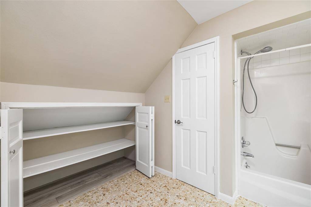 This spacious bathroom offers ample storage, with plenty of cabinet space to keep essentials organized. The generous layout ensures both comfort and practicality for everyday use