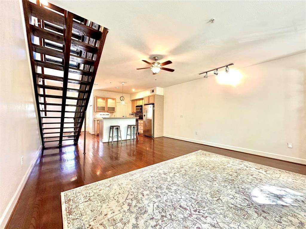 Another view of the large living area with ceiling fan and track lighting.