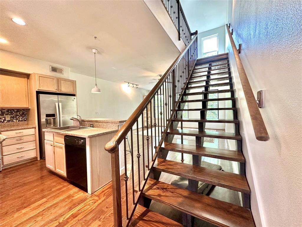 The floors have been upgraded with designer flooring. Stairs lead to second floor of unit.