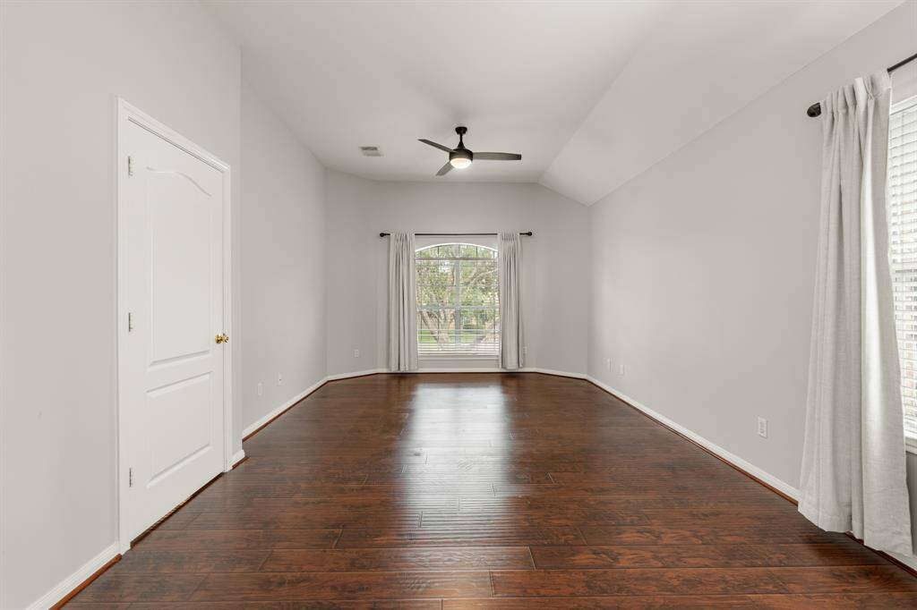 The primary bedroom welcomes you with bright natural light, wood flooring, a modern ceiling fan, and fresh paint! It sits at the back of the home offering additional privacy and easily fits a king size bed plus furniture!