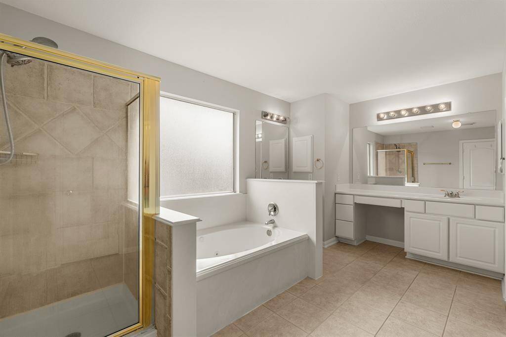 Indulge in the spaciousness of this primary bathroom featuring dual vanities, a walk-in shower, an dlarge soaking tub!