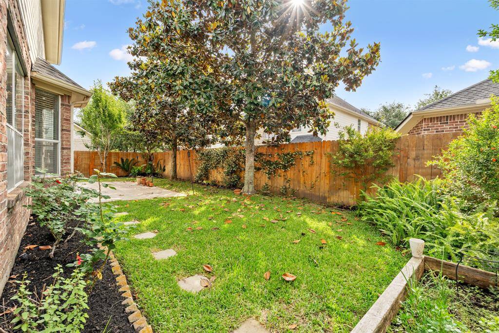 Step outside to enjoy the expansive backyard, complete with lush landscaping, mature trees, and extended concrete area — the perfect setup for outdoor dining, lounging, or weekend barbecues.