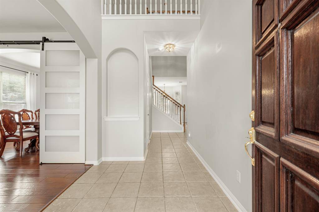 Walking in, you find a bright entryway with ceramic tile and wood flooring! It features high ceilings, a decorative art niche, and neutral paint