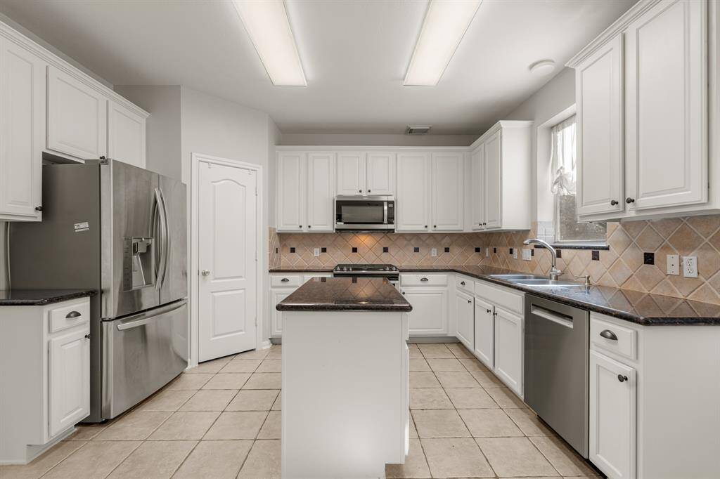 The heart of the home! This spacious kitchen features white cabinets, granite countertops, stainless steel appliances, tiled backsplash, and a walk-in pantry!