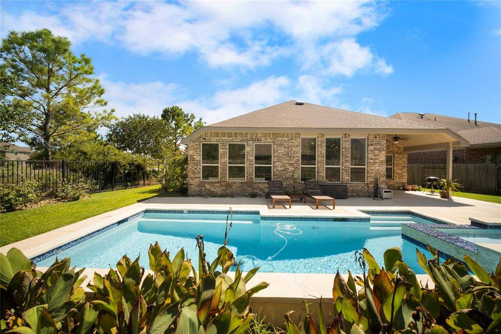 Great backyard with a sparkling pool and spa, and a cozy patio area, perfect for relaxation and entertaining.
