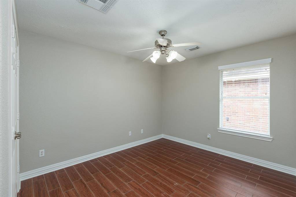 Secondary bedroom #2 with wood-looking tiles and ceiling fan