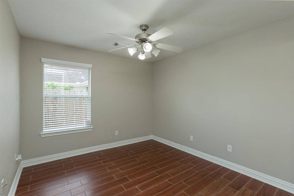 Secondary bedroom #3 with wood-looking tiles and ceiling fan