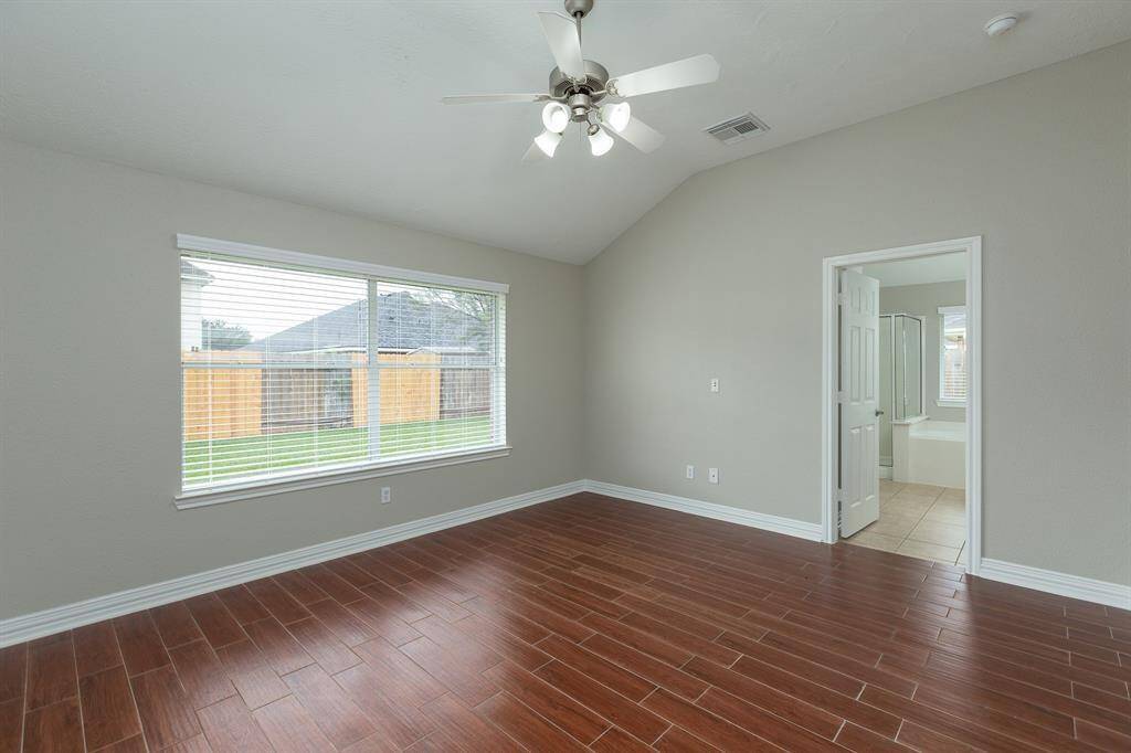 Large master retreat with high ceiling and wood-looking tile floor