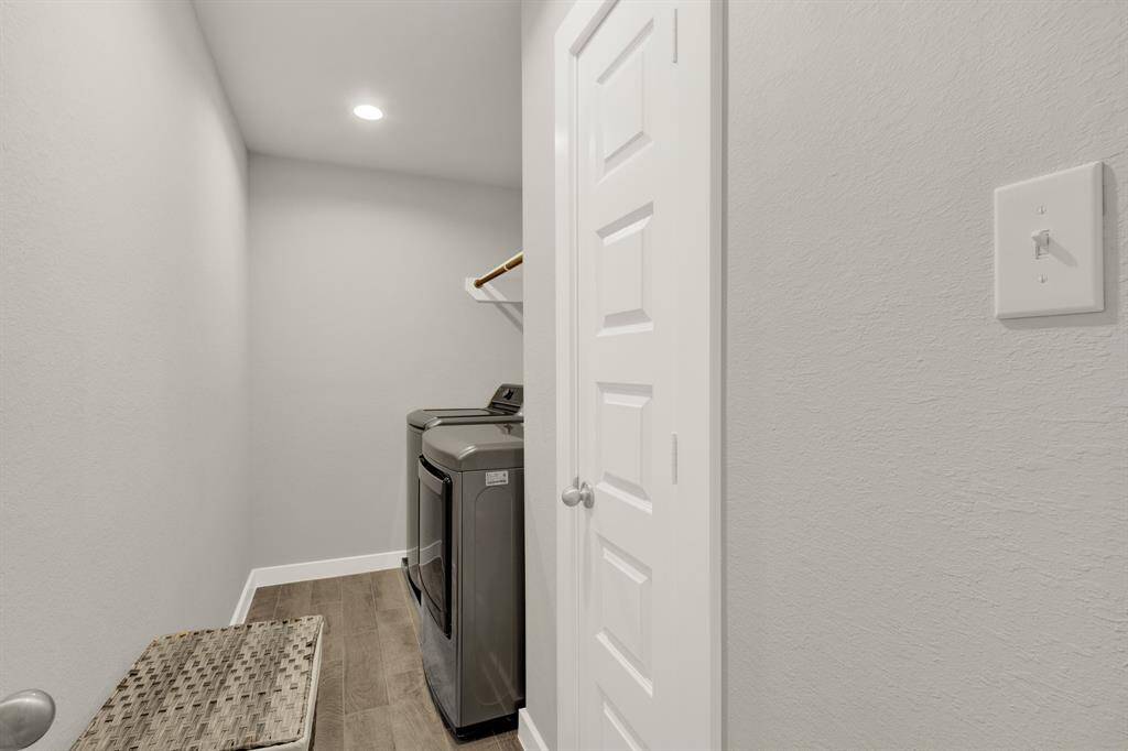 Laundry room located on the second floor, neutral gray walls, and recessed lighting.