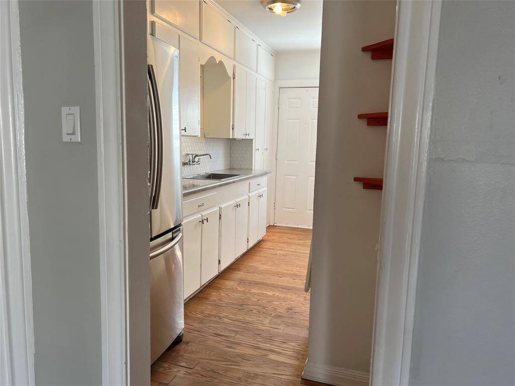 Adorable, vintage kitchen with large, stainless refrigerator