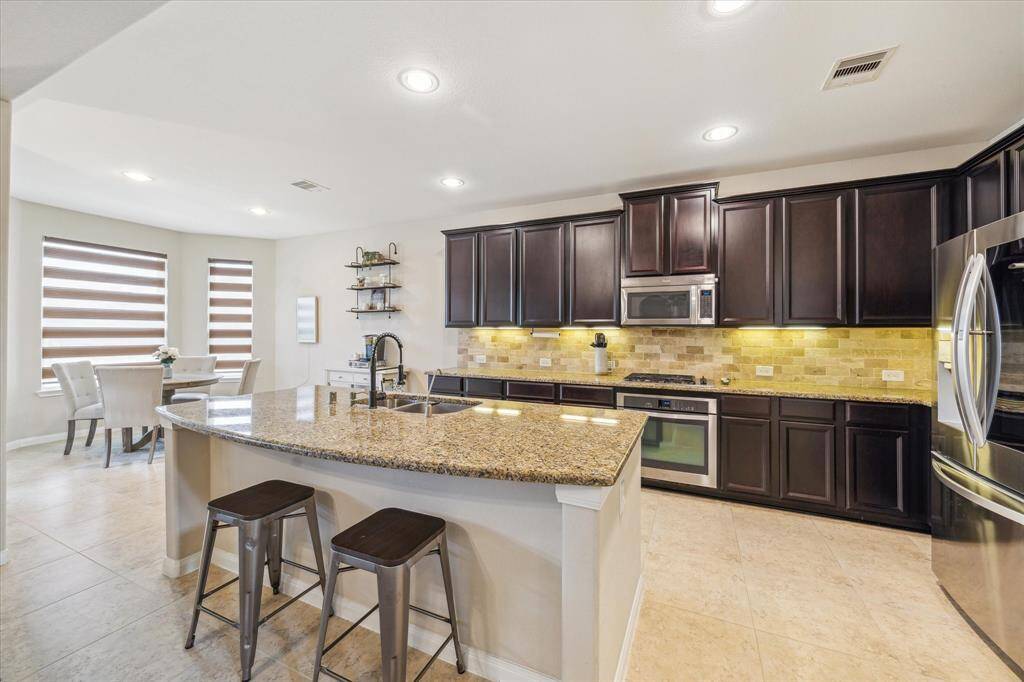 Oversized granite island offering additional seating, ideal for casual dining or entertaining.