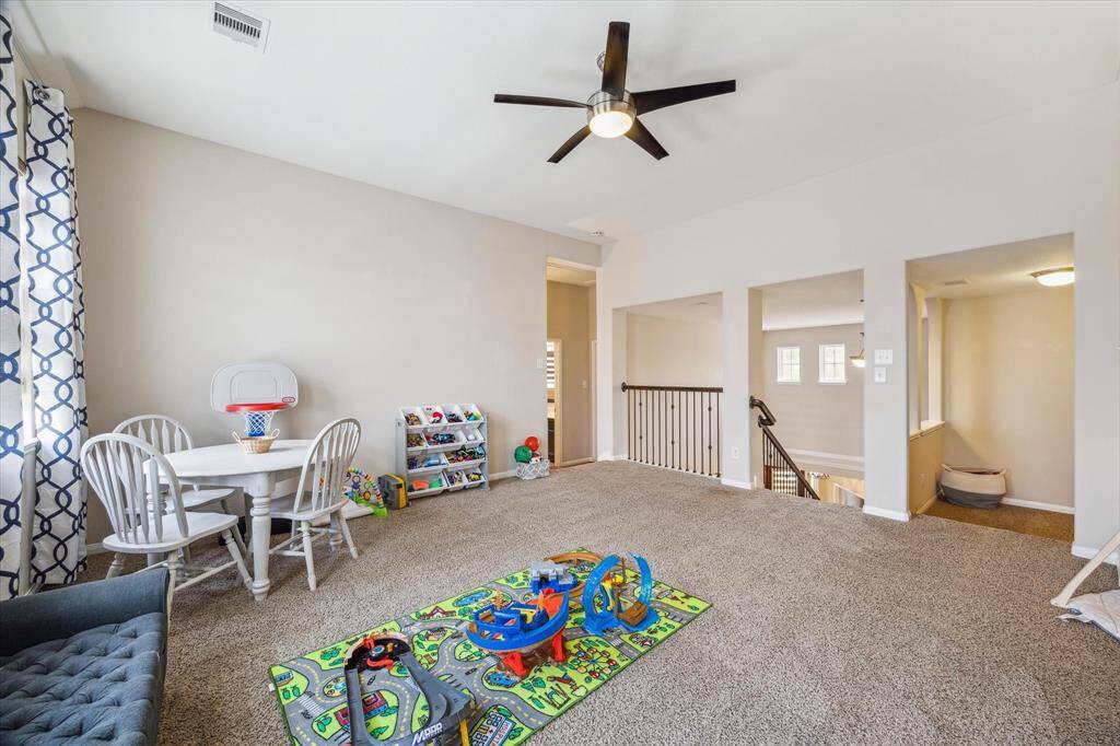 Game room located just off the staircase, with an additional attached flex room, offering versatile space for various activities.