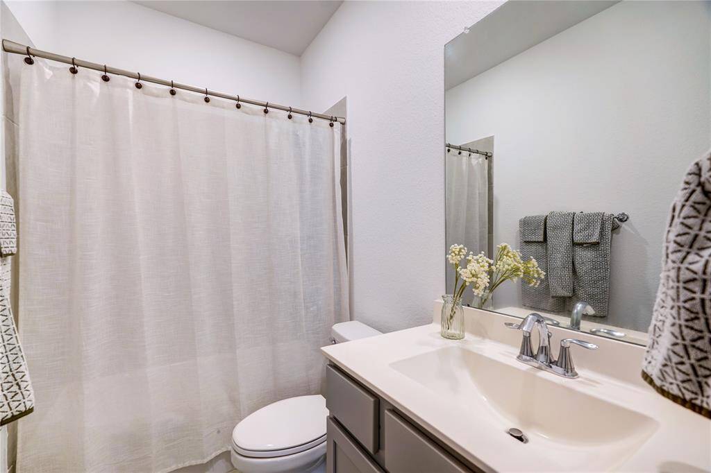 Secondary bathroom with quartz countertops and shower/tub combo.