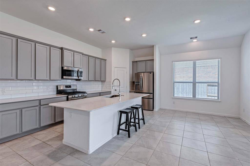 Another view of your beautiful kitchen with walk-in pantry. The elongated island overlooks the living room.