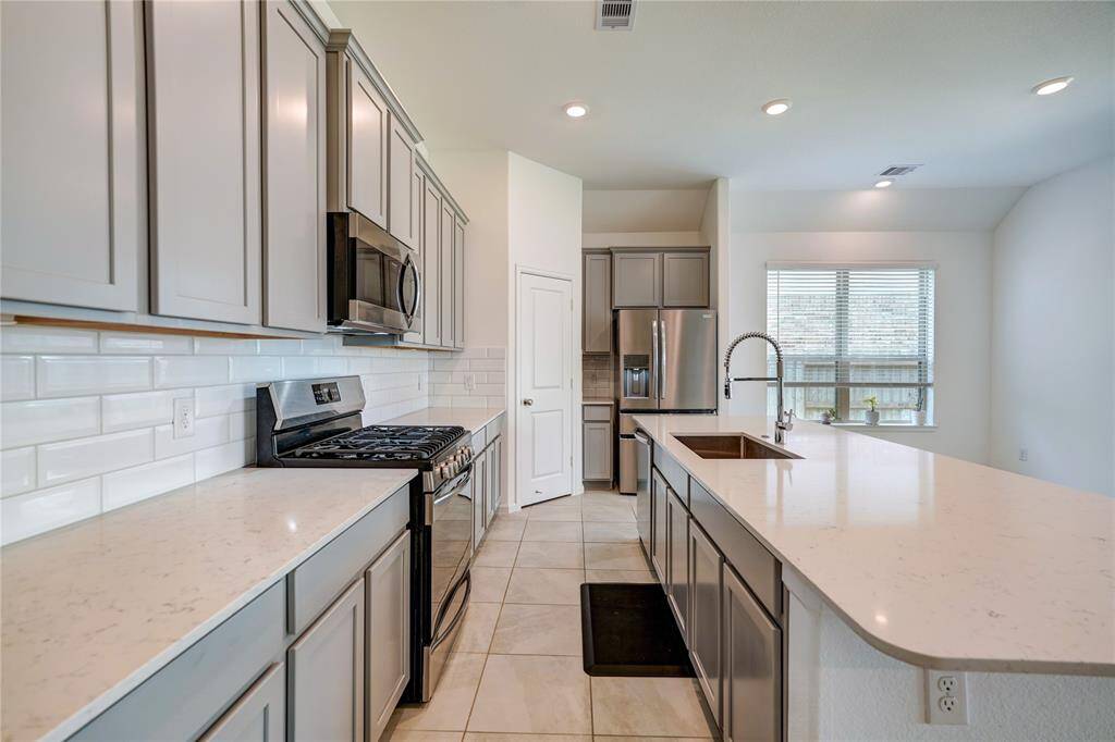 This kitchen is a chef's dream with all of this counterspace! These beautiful quartz countertops compliment the 42" cabinets perfectly. All appliances are stainless steel and remain with the home...and yes, that includes the refrigerator!