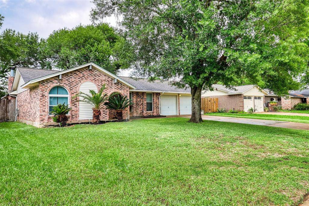 Charming brick home with a spacious front yard and mature trees. Features a two-car garage, well-maintained lawn, and attractive landscaping that adds to its curb appeal.