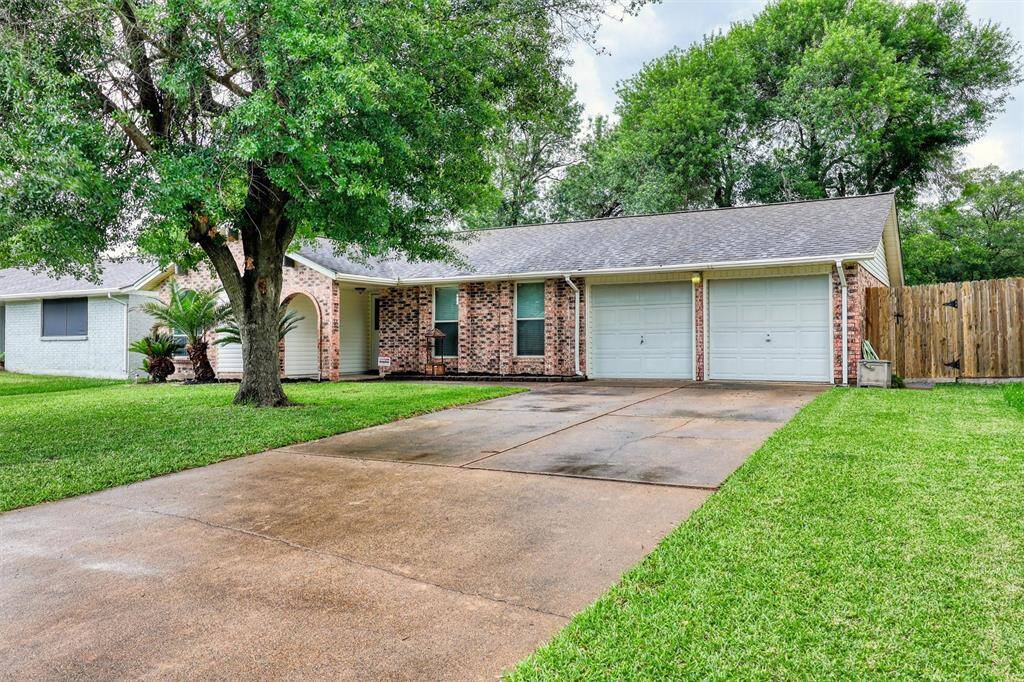 Charming single-story brick home with a spacious driveway and two-car garage. Features a well-maintained front yard with mature trees and a welcoming front entrance. Ideal for comfortable living.