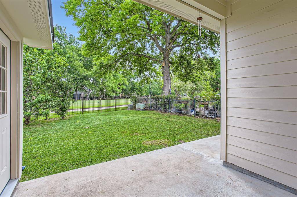This photo showcases a charming backyard, a large tree providing shade.