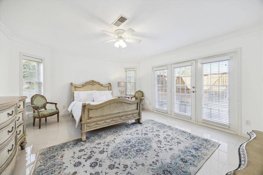 Primary bedroom on the first floor with a double French door access to the private backyard.