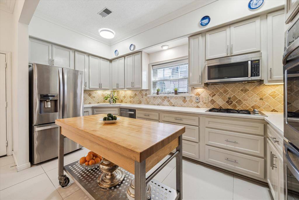 Kitchen features a bright and inviting design with a neutral color palette and ample storage.