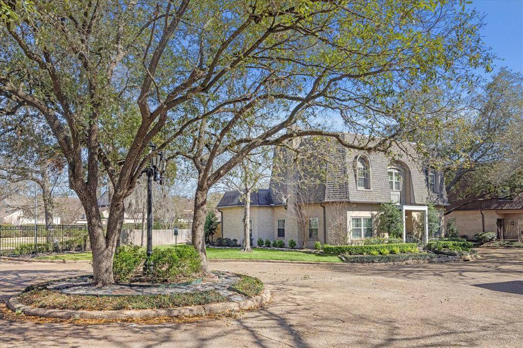 Another view of the front with beautiful trees.