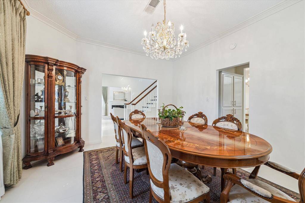 Spacious dining room with a sparkling chandelier, easily accessible to the kitchen.