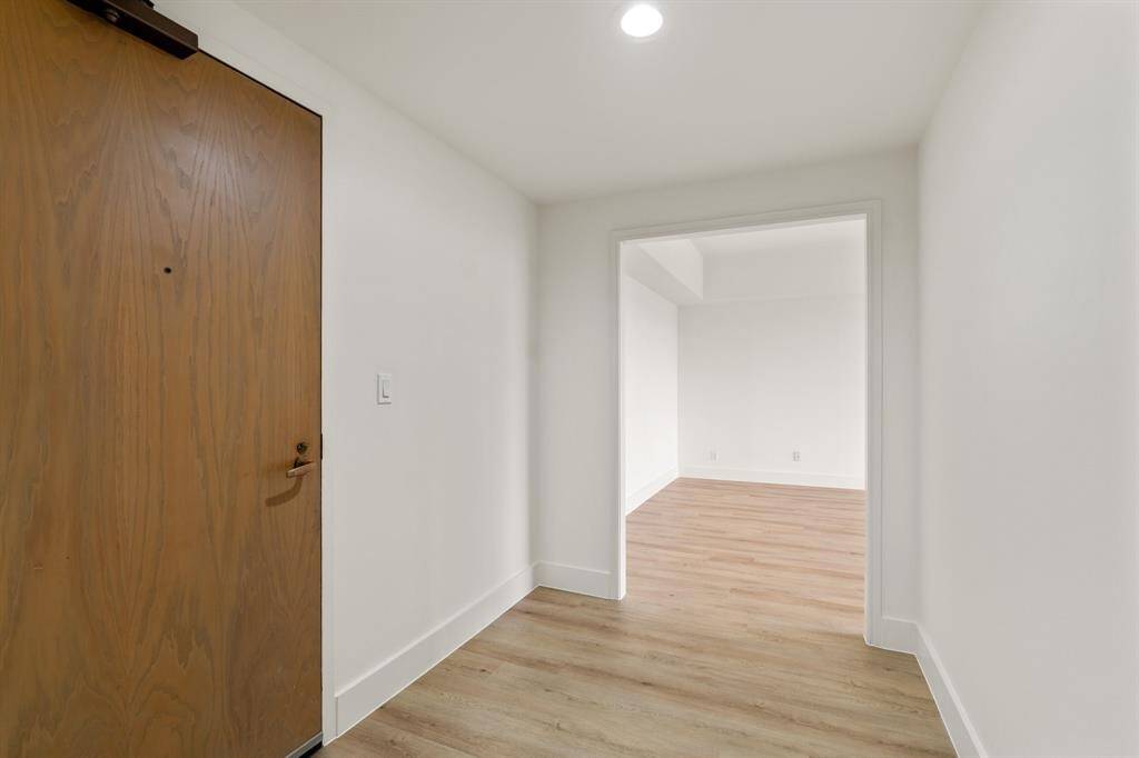 Entry with wide plank vinyl flooring, freshly painted throughout, new baseboards and recessed lighting.