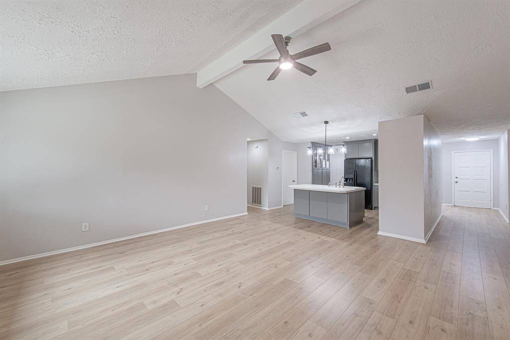 The floors perfectly complement the soft decorator paint.  The primary suite is located through the passage to the left of the kitchen.
