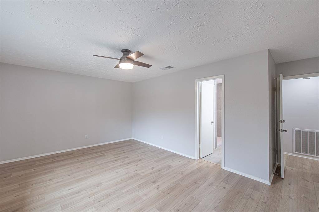 Alternate view of the primary bedroom shows the entry to the en-suite bathroom.  At nearly 12x18, there is plenty of space for a king size furniture suite.