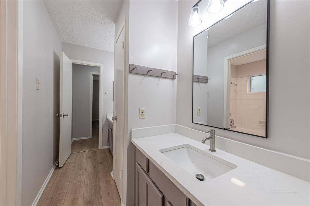 A Jack-and-Jill bathroom connects the two secondary bedrooms.  Don't miss the linen closet located just outside the bathroom.  This vanity features a modern light fixture, quartz counters, freshly painted cabinets, framed mirror, brushed nickel faucet, and medicine cabinet.