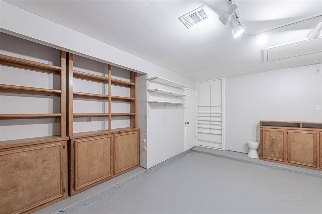 Note the expansive built in shelving and cabinetry, epoxy floors, track lighting, and fresh paint.  The second garage space is where you will find the washer and dryer.
