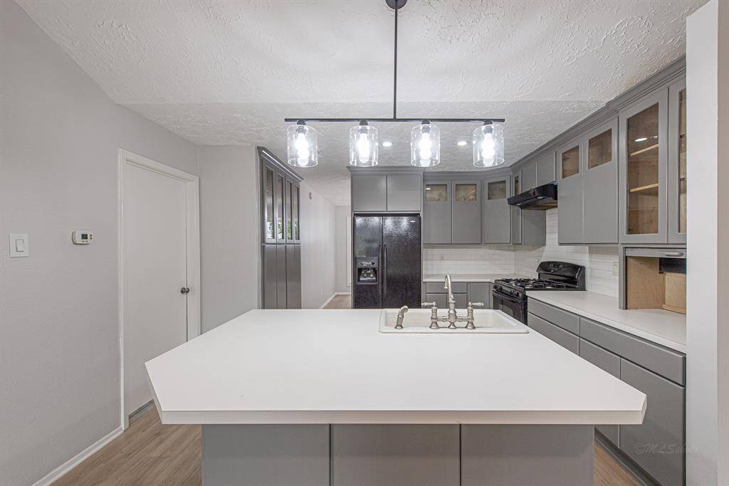 Step through the dining room passage to find your island kitchen! A deep built-in pantry is in the hallway that connects the kitchen to the dining room.  The kitchen has been beautifully updated with painted cabinets, timeless subway tile backsplash, and sleek black appliances.
