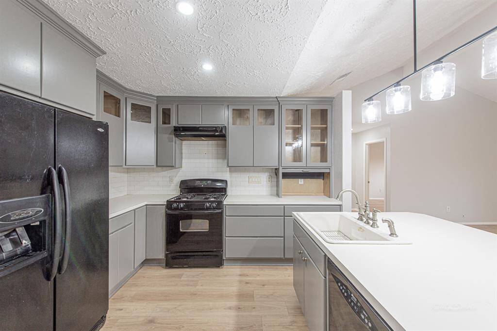 You won't run out of storage here! Note that the cabinetry extends to the ceiling.  Display your decorative dishware or favorite serving pieces in the glass-front cabinets. Note the recessed LED lighting and the modern pendant over the island.