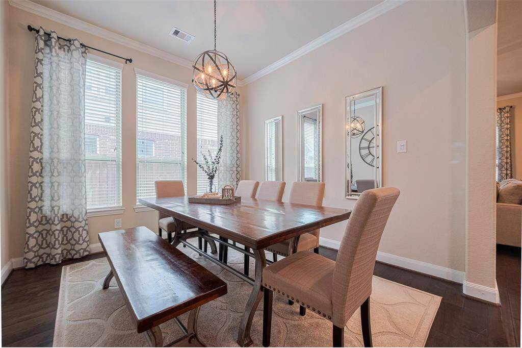 Defined by a broad archway, this formal dining room creates a sense of intimacy while remaining open to the flow of the home. Tall windows brighten the room, and a sculptural chandelier serves as a striking focal point for both everyday meals and special occasions.