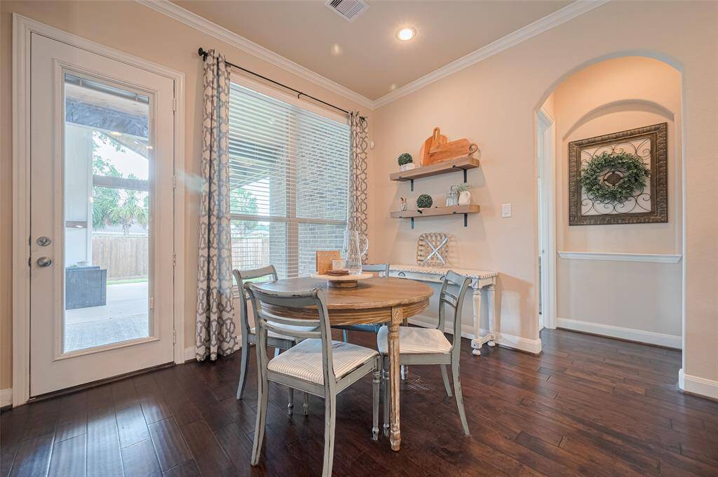 Nestled in a sunny corner, the breakfast area is framed by an oversized window and a glass-paneled door that opens to the patio. Its open design connects naturally with both the kitchen and living areas, offering a bright, easygoing space to start the day.