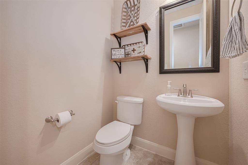 A thoughtfully placed powder room featuring the essentials—sink, mirror, and subtle lighting—convenient for guests and daily use.