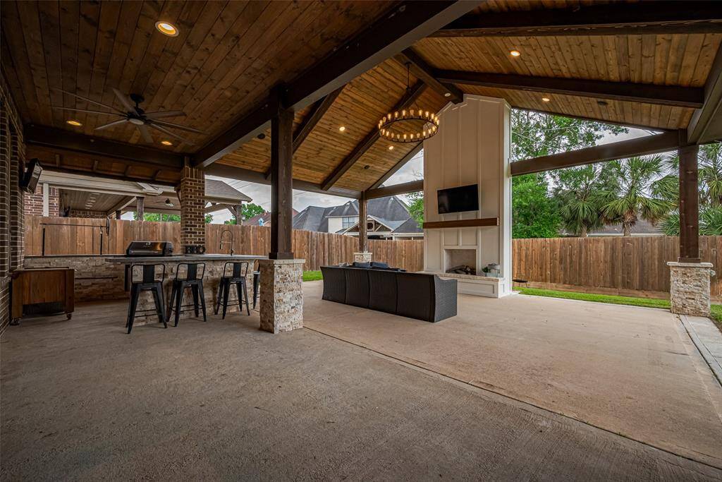 Newly added and thoughtfully designed, the covered patio offers a true extension of the home. Outfitted with recessed and statement lighting, a ceiling fan, and a cozy fireplace, the space also includes a built-in bar counter for outdoor cooking and entertaining.