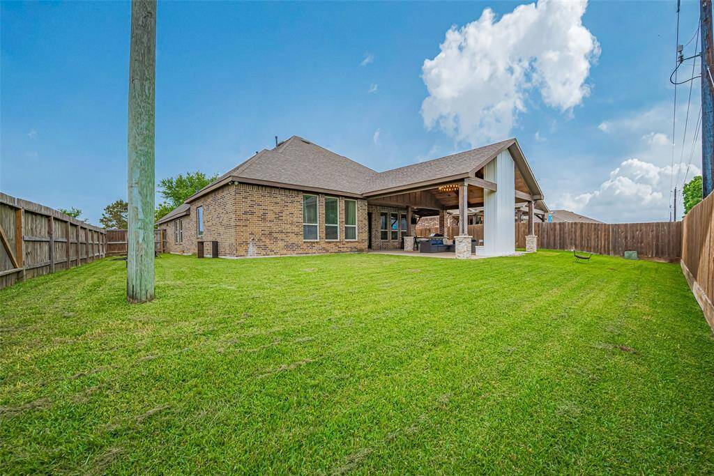 The backyard offers an impressive stretch of green lawn, fully fenced for privacy and ready for recreation, gardening, or peaceful outdoor enjoyment.