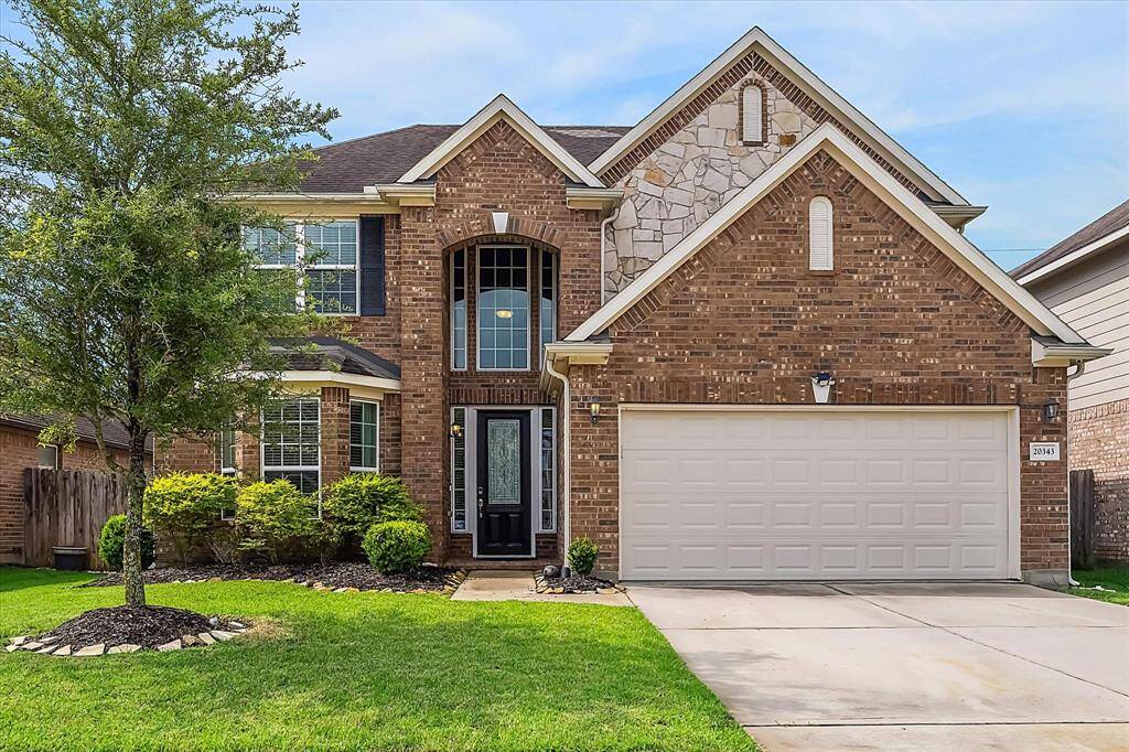 Welcome to this charming two-story brick home featuring a gabled roof and an attached two-car garage. The entrance boasts a prominent arched doorway with large windows for natural light.