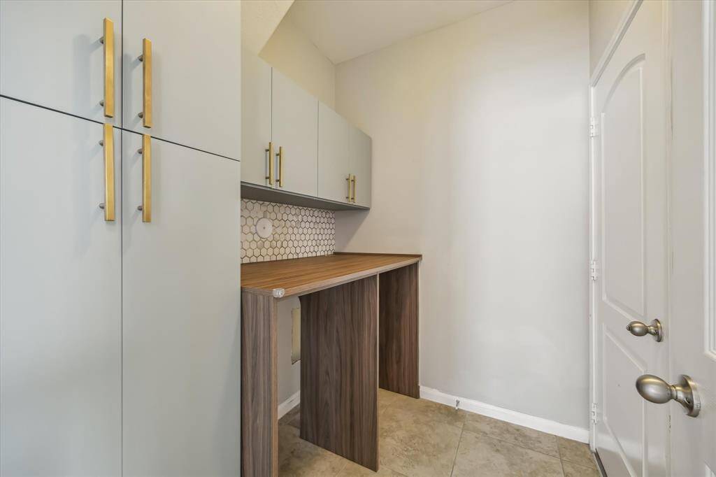 Utility Room featuring custom cabinets and accent tile