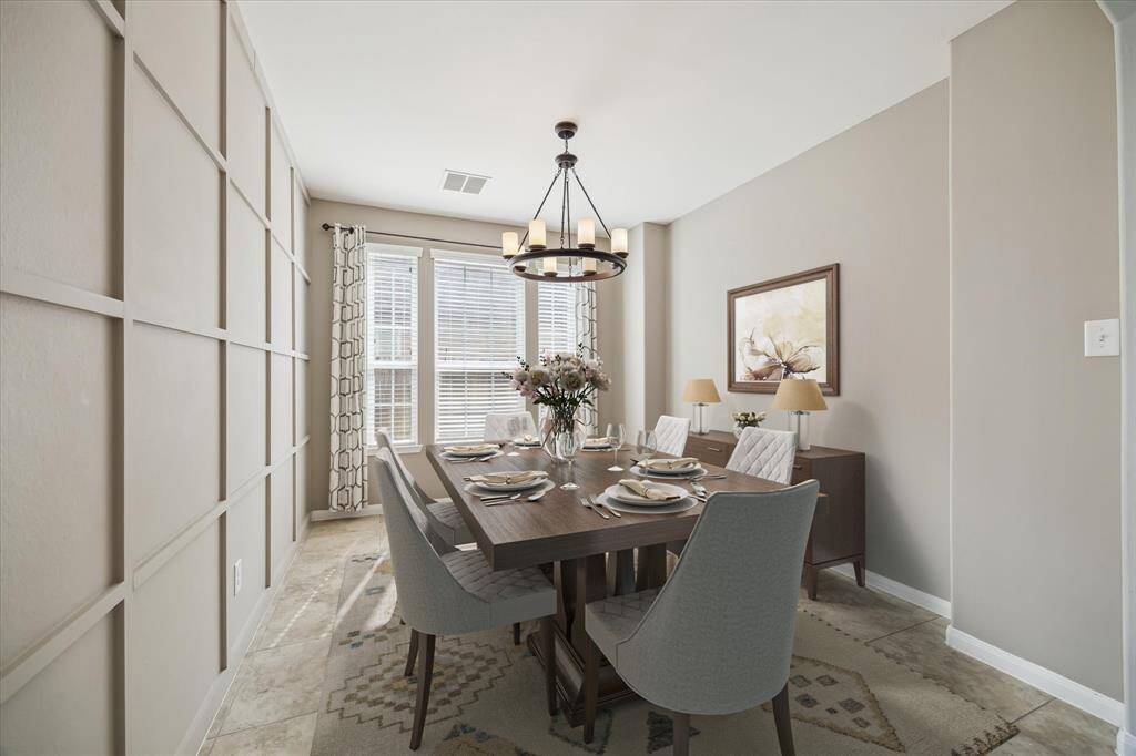 The formal dining is enhanced with decorative paneling and features an upgraded chandelier and wall to wall windows *virtually staged