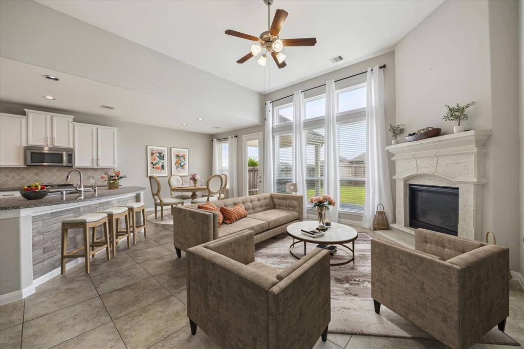 The heart of the home offers a spacious open floor plan with soaring ceilings and an oversized wall of windows overlooking private back yard *virtually staged