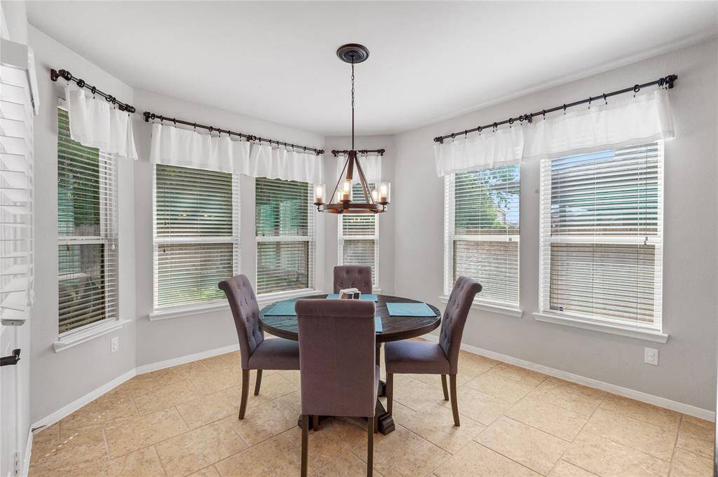 How can you not love all the sunny windows surrounding the breakfast room?  Notice the elegant light fixtures in this home as well.