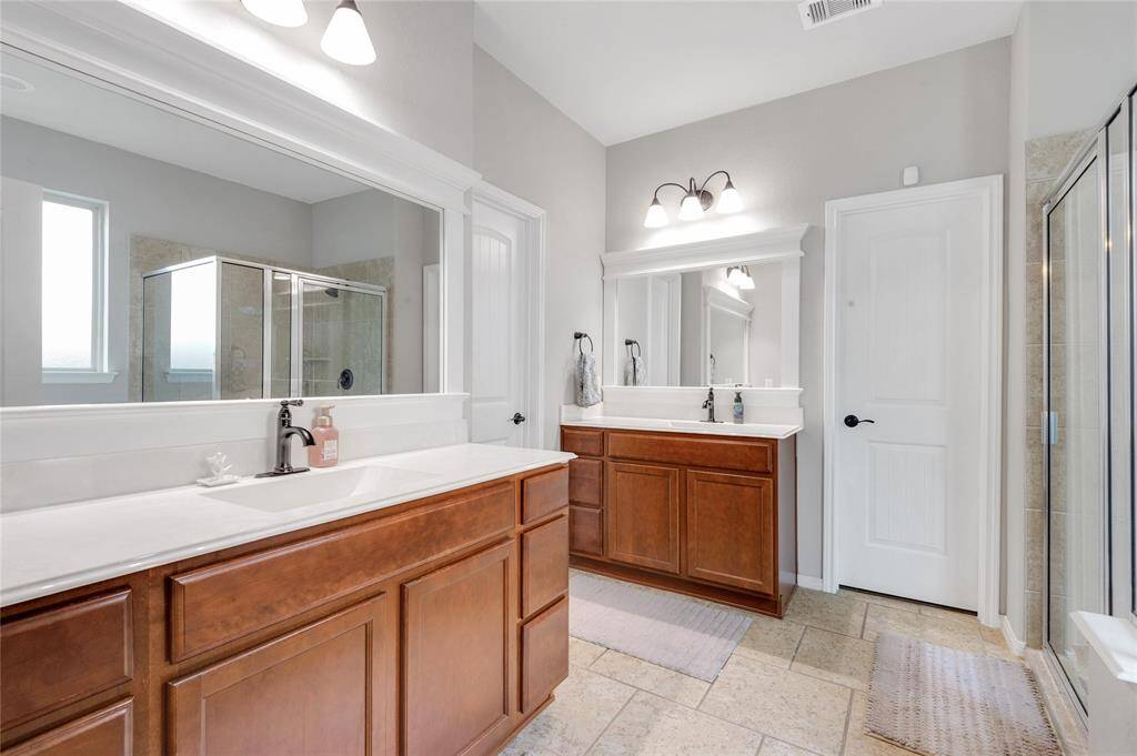 His and her vanities and sinks are a huge bonus in this primary bathroom.