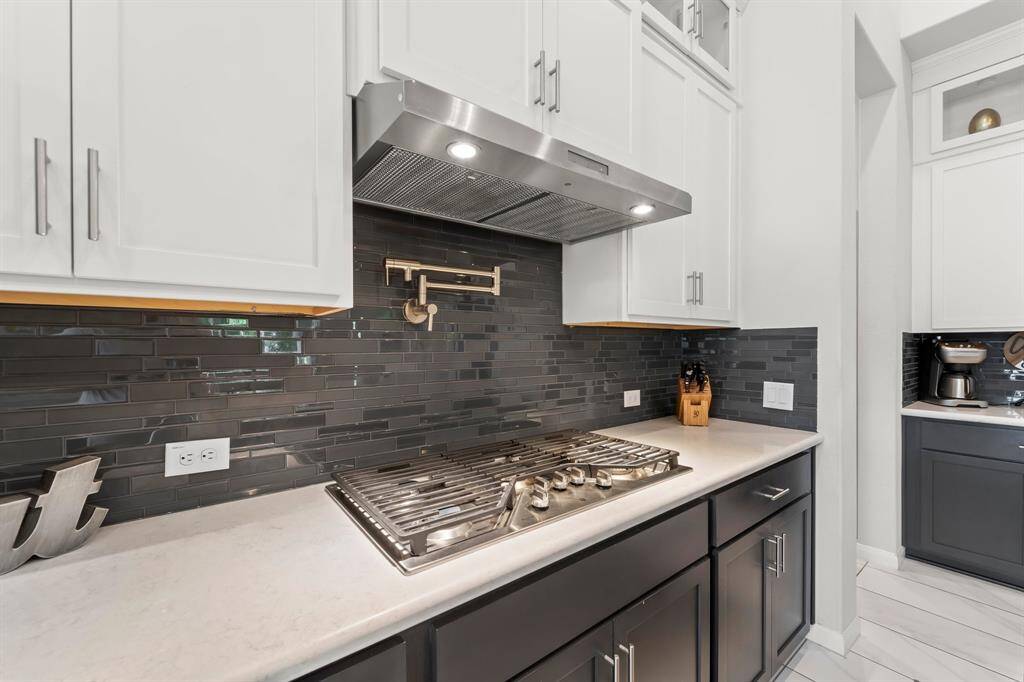 The stove is fully equipped with a 5 burner gas cooktop and pot filler.