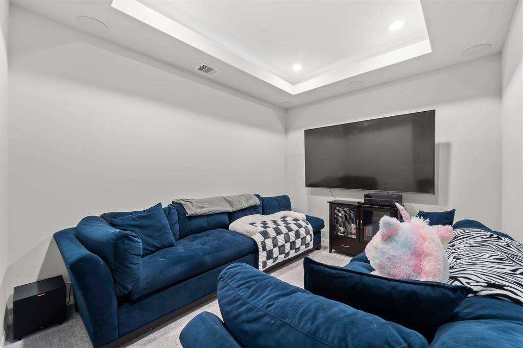 The room next to the office is this sitting area being used as a media room. This room has a trey ceiling and uplights to add to the ambiance.