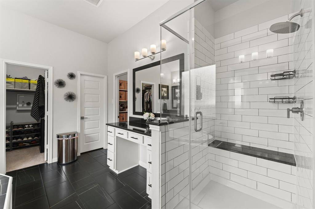 One side of the large primary bathroom has it's oversized shower with a built-in bench and a separate vanity area.